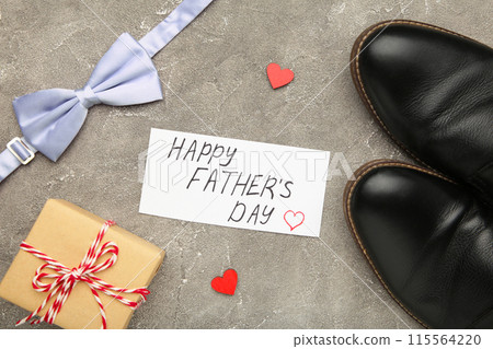 Happy Fathers Day message and black shoes on grey concrete background. Happy Fathers Day message and black shoes on grey concrete background. 115564220