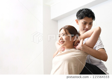 一名男子正在為一名女病人進行按摩治療 115564333