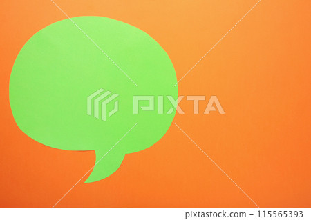 Green paper speech bubble on orange background 115565393