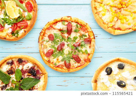 Variety of pizzas on blue wooden background 115565421