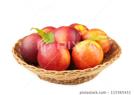 Nectarines in a basket isolated on white background 115565431