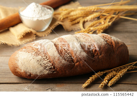 Delicious freshly baked brown bread on grey wooden background 115565442