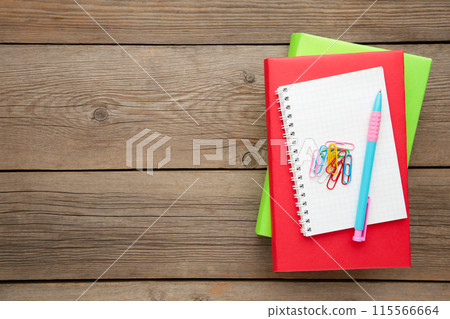 Colorful school books with pen on grey wooden background Colorful school books with pen on grey wooden background 115566664