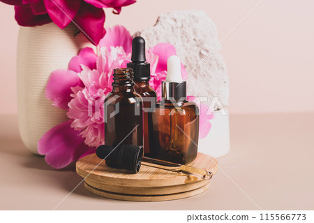 Mock up glass dropper bottle trendy podium with pastel background, flowers and stones, abstract background  115566773