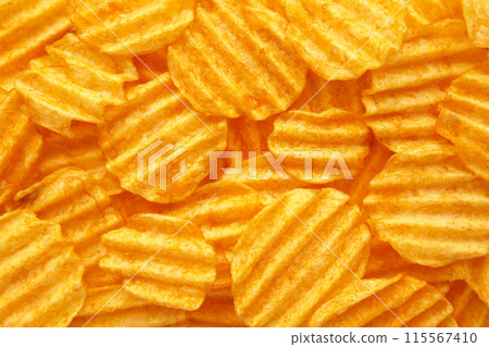 Rippled golden potato chips background with copy space for text 115567410