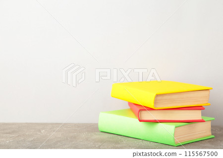 Multi coloured school books on grey background 115567500