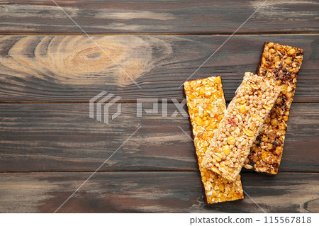 Energy bars - snack for healthy still life with copy space on brown background. Energy bars - snack for healthy still life with copy space on brown background. 115567818