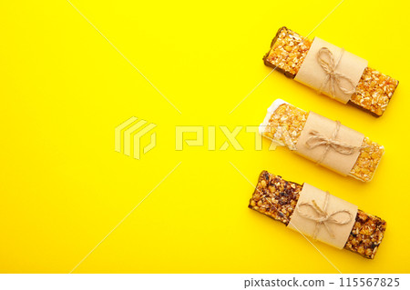 Energy bars - snack for healthy still life with copy space on yellow background. Energy bars - snack for healthy still life with copy space on yellow background. 115567825
