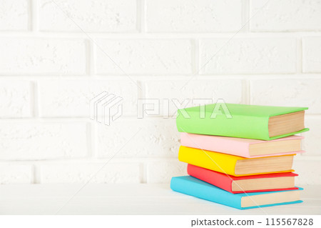 Multi coloured school books on a white background with copy space. 115567828