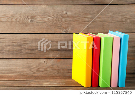Multi coloured school books on a grey wooden background with copy space. 115567840