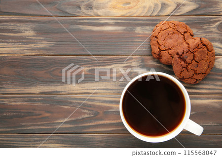 Cup of coffee and chocolate cookies on brown wooden table Cup of coffee and chocolate cookies on brown wooden table 115568047