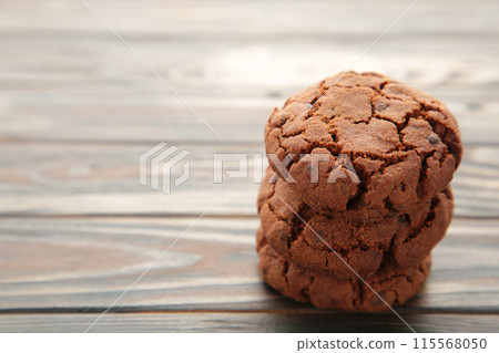 Chocolate chips cookies on brown wooden background. Chocolate chips cookies on brown wooden background. 115568050