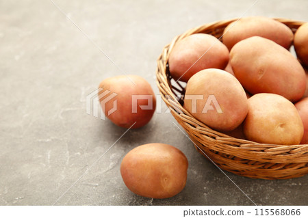 Basket of fresh tasty new potatoes on grey background 115568066