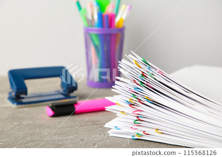 White paper with multicolored clips and stationery on grey 115568126