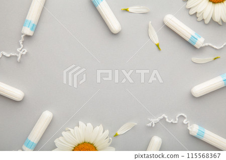 Medicinal chamomile flower and menstrual sanitary tampon. Woman critical days, gynecological menstruation cycle. Medicinal chamomile flower and menstrual sanitary tampon. Woman critical days, gynecological menstruation cycle. 115568367