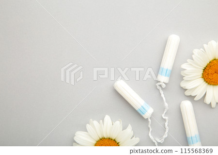 Medicinal chamomile flower and menstrual sanitary tampon. Woman critical days, gynecological menstruation cycle. Medicinal chamomile flower and menstrual sanitary tampon. Woman critical days, gynecological menstruation cycle. 115568369