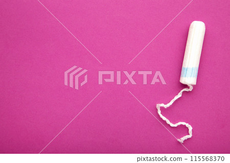 Menstrual tampon on a pink background. Cotton tampon for women Menstrual tampon on a pink background. Cotton tampon for women 115568370