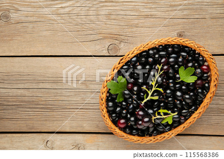 Basket with black currant on grey wooden background with copy space Basket with black currant on grey wooden background with copy space 115568386