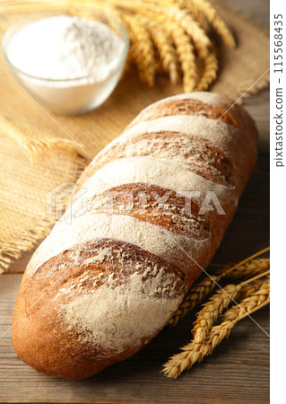 Delicious freshly baked brown bread on grey wooden background Delicious freshly baked brown bread on grey wooden background 115568435