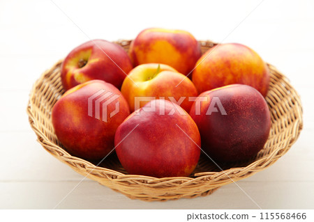 Nectarines in a basket on white background Nectarines in a basket on white background 115568466