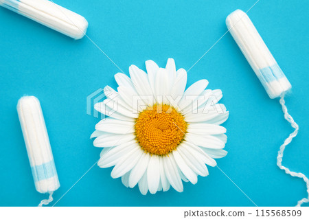 Medicinal chamomile flower and menstrual sanitary tampon. Woman critical days, gynecological menstruation cycle. 115568509