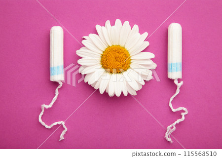 Medicinal chamomile flower and menstrual sanitary tampon. Woman critical days, gynecological menstruation cycle. Medicinal chamomile flower and menstrual sanitary tampon. Woman critical days, gynecological menstruation cycle. 115568510