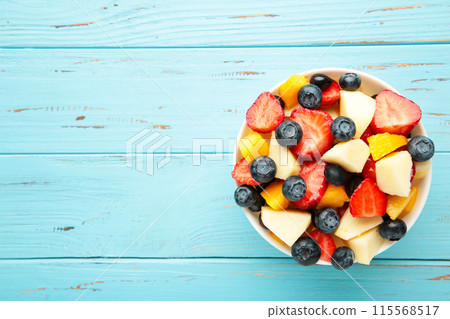 Salad with fresh fruits and berries on blue wooden background Salad with fresh fruits and berries on blue wooden background 115568517