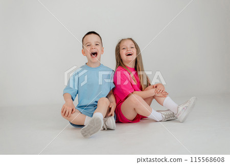 Little couple kids boy girl 4-5 years old clothes shirt dress posing have fun isolated on white background children studio portrait. People childhood lifestyle 115568608