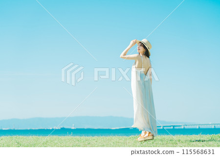A woman in a dress enjoying vacation at a resort 115568631