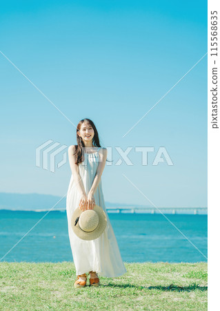 A woman in a dress enjoying vacation at a resort 115568635