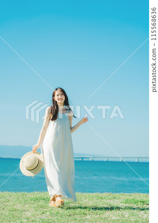 A woman in a dress enjoying vacation at a resort 115568636