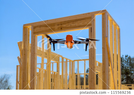 Monitoring contractor inspects construction site with drone 115569236
