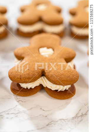 Gingerbread cookies filled with eggnog buttercream stand out, their rich hue complementing the eggnog buttercream, against a gentle background. These festive treats exude a homemade allure. 115569275