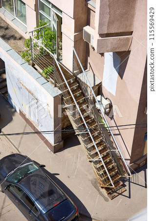 Metal staircase on the edge of the house, top view Metal staircase on the edge of the house, top view 115569429