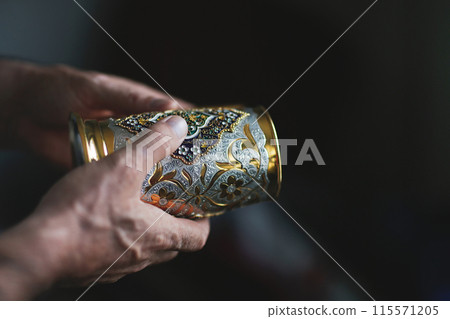 Jewellery maker working in workshop crafting silver vase Jewellery maker working in workshop crafting silver vase 115571205