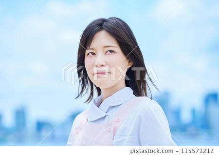 一個穿著白大褂和圍裙的年輕女子 一個穿著白大褂和圍裙的年輕女子 115571212