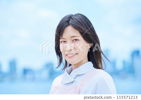 一個穿著白大褂和圍裙的年輕女子 一個穿著白大褂和圍裙的年輕女子 115571213