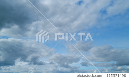 Unusual cirrus and cumulus on different layers clouds in blue sky. Wide angle contrast daytime nature background. Timelapse. 115571498