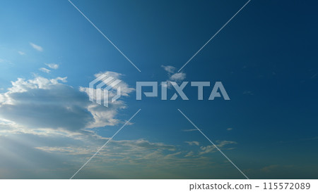 Bright rays of the sun shining through clouds. Bright sun on blue summer sky with moving fluffy clouds. Timelapse. Bright rays of the sun shining through clouds. Bright sun on blue summer sky with moving fluffy clouds. Timelapse. 115572089