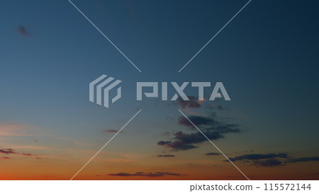 Panoramic view. Sunset sky with condensation trail. Dramatic warm near and far clouds at sunset. Timelapse. 115572144