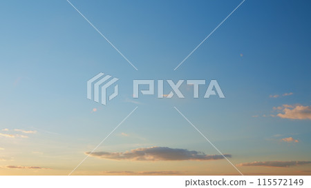 Beautiful sunset with clouds. Sun shines at the level of the horizon and warm tones colors. Timelapse. 115572149