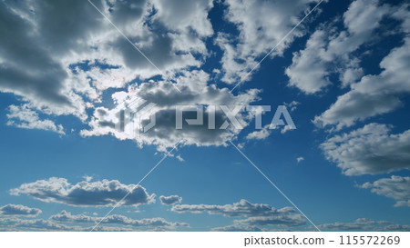 Beautiful blue sky with sunbeams and clouds. Clouds at blue sky background. Sunny cloudscape. Timelapse. 115572269