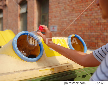 woman throwing plastic bottle Recycling bin stand on european street. Waste separation rubbish before drop to garbage bin to save world, environment care. Pollution trash recycling management concept 115572375