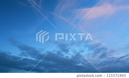 Beautiful sunset with cirrus clouds. Sun shines at level of horizon and warm tones colors. Timelapse. 115572403