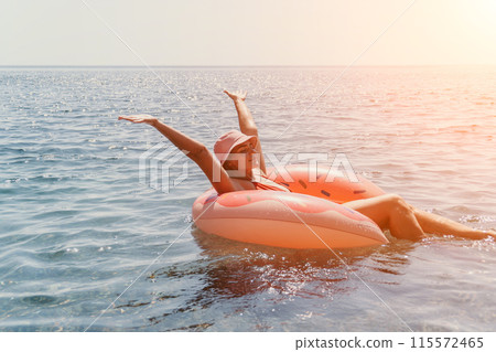 Summer Vacation Woman floats on an inflatable donut mattress, a water toy swim ring. Positive happy woman relaxing and enjoying family summer travel holidays vacation on the sea. Slow motion Summer Vacation Woman floats on an inflatable donut mattress, a water toy swim ring. Positive happy woman relaxing and enjoying family summer travel holidays vacation on the sea. Slow motion 115572465