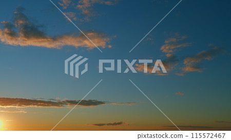 Intense dramatic panoramic sunset. Abstract different shades clouds at sunset sky background. Timelapse. 115572467