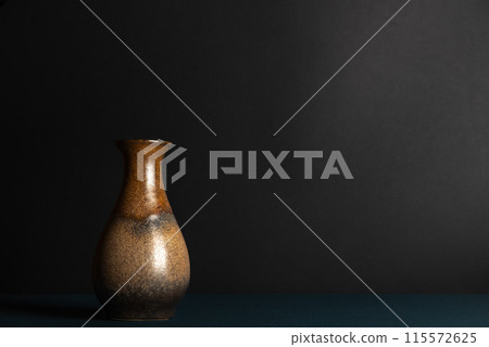 Empty vintage brown ceramic vase on a black background. Still life, plenty of space for text. Empty vintage brown ceramic vase on a black background. Still life, plenty of space for text. 115572625