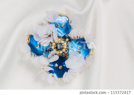 Handmade blue mother-of-pearl brooch , close-up Handmade blue mother-of-pearl brooch , close-up 115572817