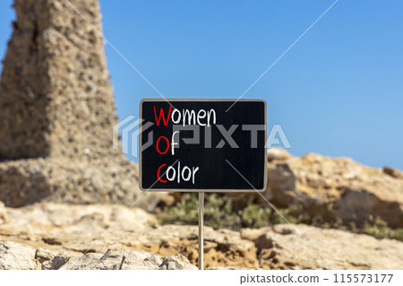 WOC women of color symbol. Concept words WOC women of color on beautiful yellow blackboard. Beautiful stone blue sky background. Business WOC women of color social issues concept. Copy space. WOC women of color symbol. Concept words WOC women of color on beautiful yellow blackboard. Beautiful stone blue sky background. Business WOC women of color social issues concept. Copy space. 115573177