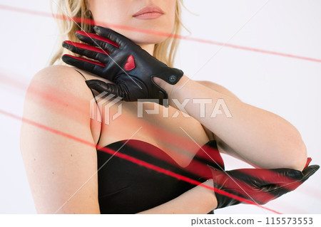 An adult woman in black gloves with a heart with red threads. 115573553